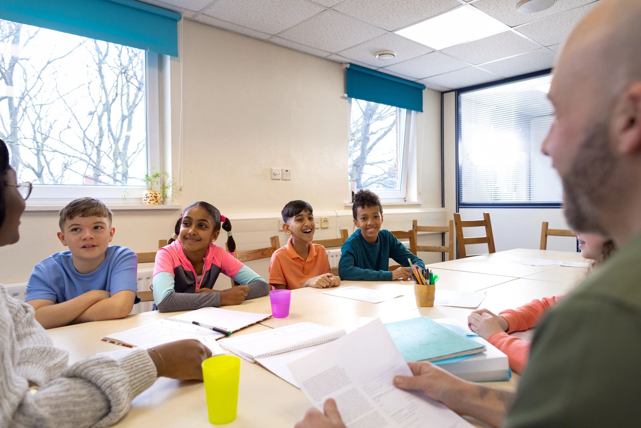 Children gathered around a table in a supportive learning environment